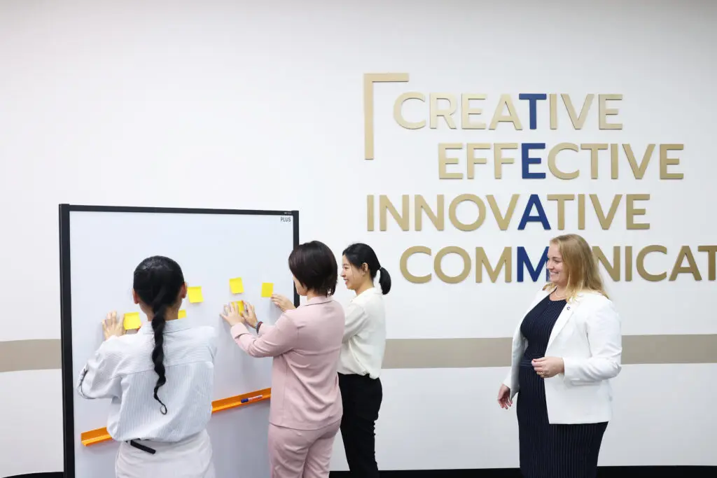 AIHM Personal Branding course participants collaborating with sticky-note exercises to develop communication, creativity, and self-presentation skills guided by an executive education trainer.
