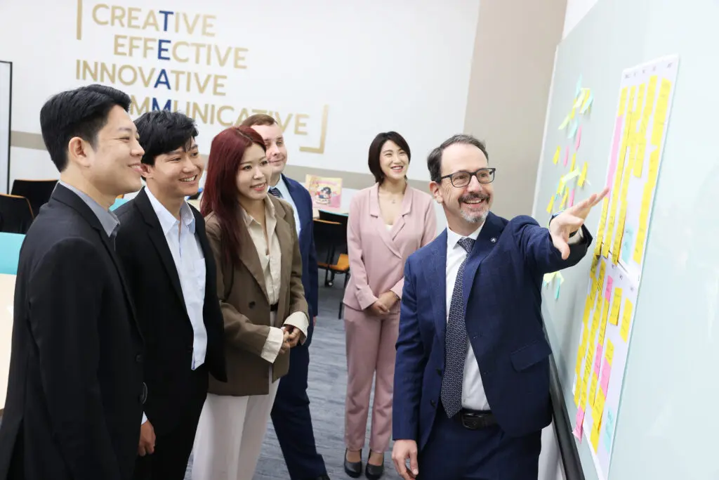 AIHM Digital Content Marketing course participants learning brand storytelling and social media strategy with instructor guidance; hands-on workshop using post-it ideation.