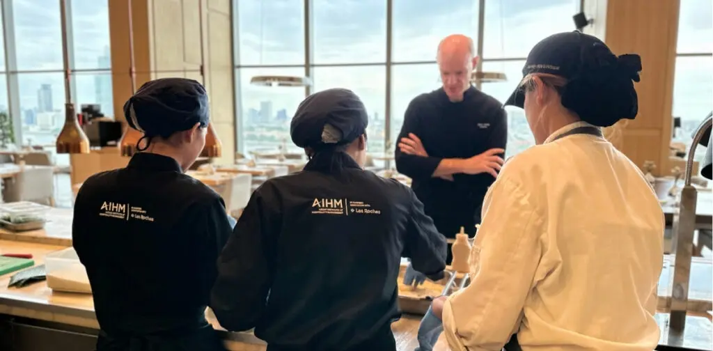 Hospitality professionals attending AIHM executive education course in food and beverage management, receiving hands-on culinary training from industry chef in Bangkok, Thailand