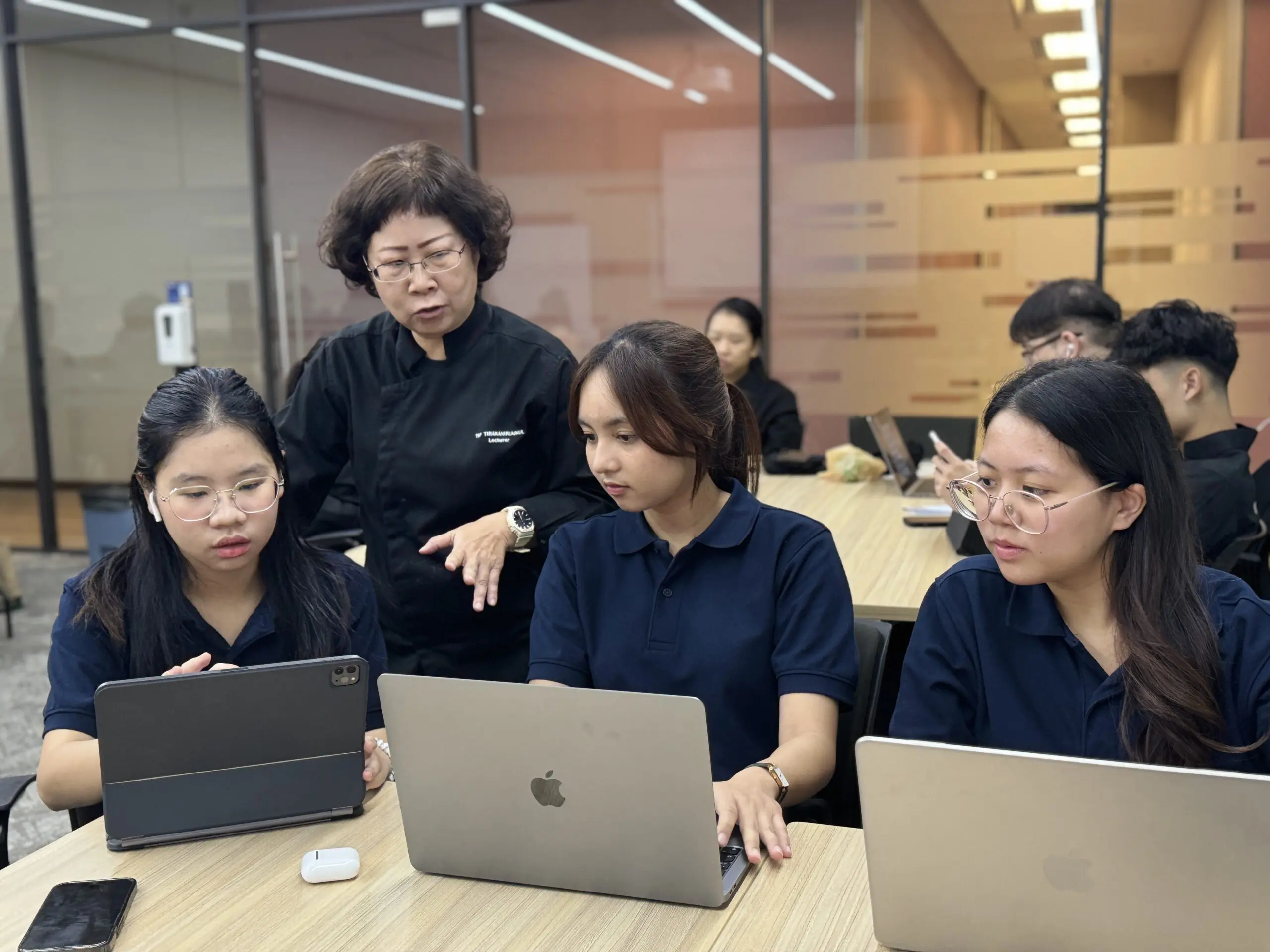 AIHM hospitality management students receive hands-on guidance from a lecturer in class, highlighting applied learning, academic excellence and Les Roches–inspired education in Bangkok.