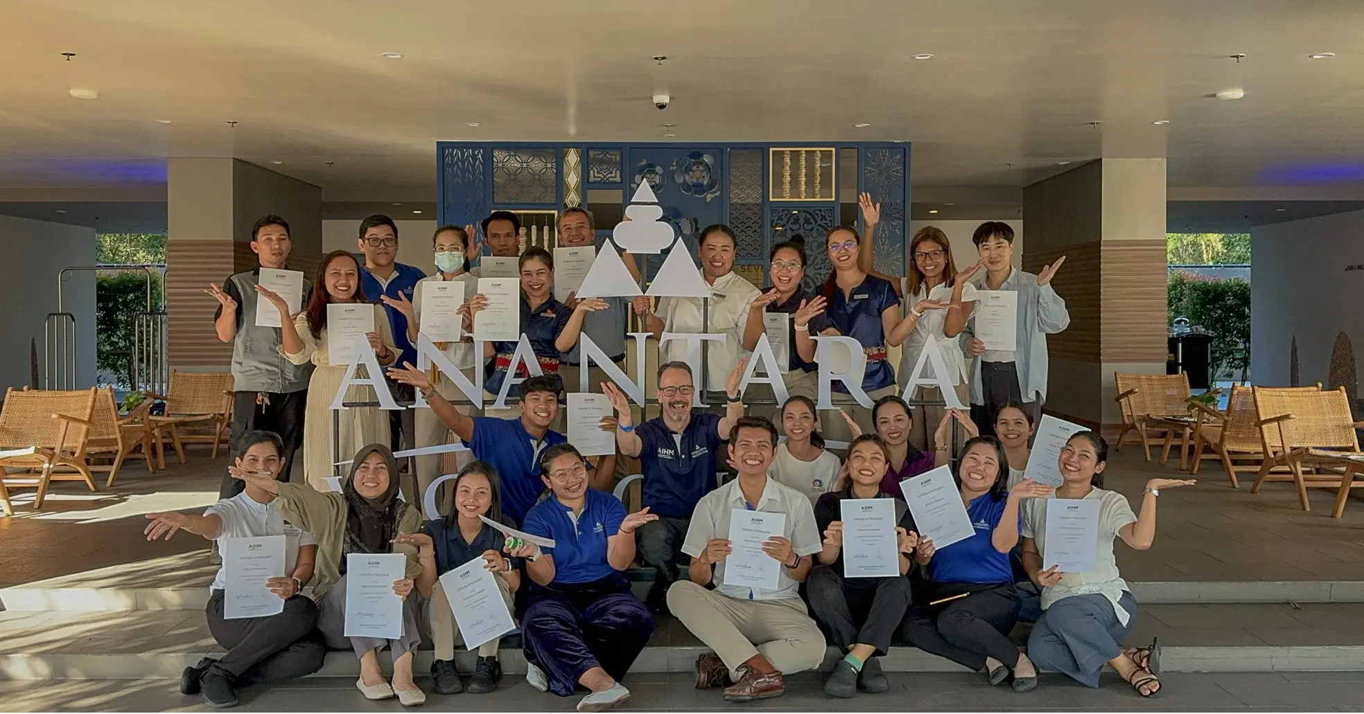 AAIHM executive education graduates at Anantara Vacation Club proudly holding certificates after a custom training programme, celebrating team development, service excellence, and upskilling success.