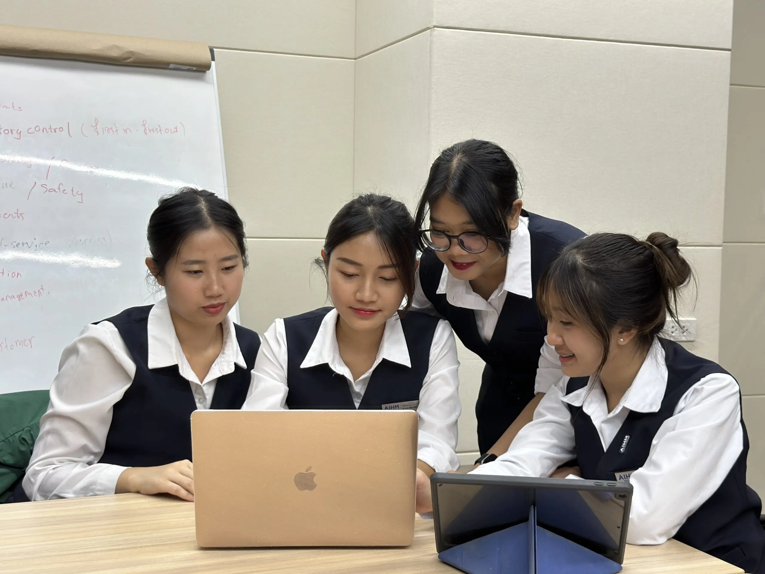 AIHM students collaborating with laptops during the BTEC Higher National Diploma in Business & Marketing, building real-world marketing, management, and analytical skills.