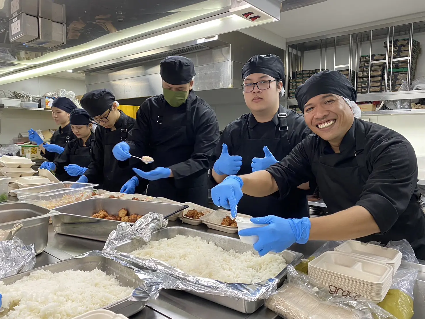 AIHM culinary students preparing donated meals as part of a CSR food support project, showcasing teamwork, hospitality skills, and community impact in Thailand.