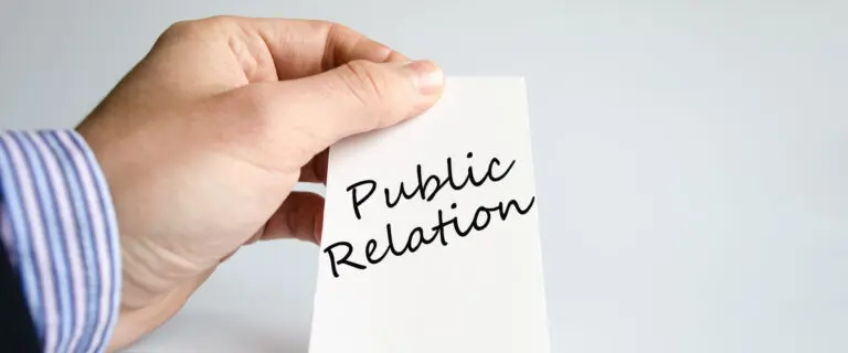 Hand holding card with public relation text, representing corporate communication, branding and stakeholder engagement