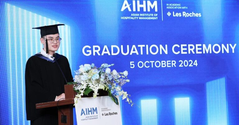 Graduate in cap and gown speaks at a podium with AIHM branding and flower arrangement. "Graduation Ceremony" text and date "5 October 2024" are visible on a blue background.