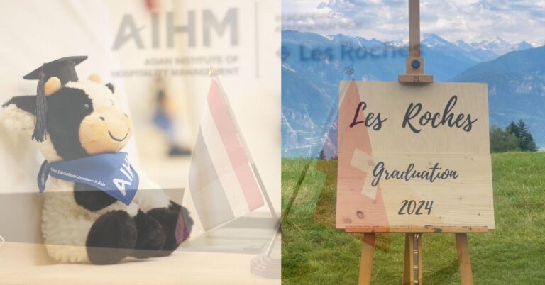A plush cow in a graduation cap and scarf sits next to a small flag with "AIHM" in the background. To the right, a wooden sign reads "Les Roches Graduation 2024" set against a scenic mountain landscape.