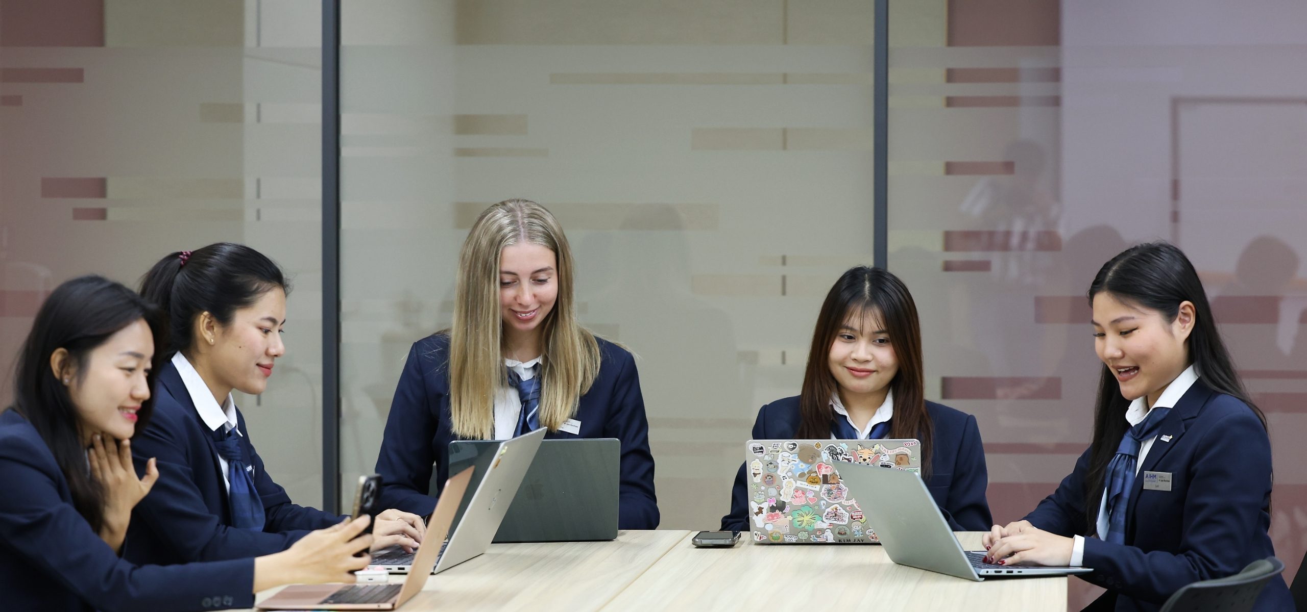 AIHM international BBA students collaborate in a dynamic hospitality management classroom, developing business, marketing, and leadership skills in academic association with Les Roches.