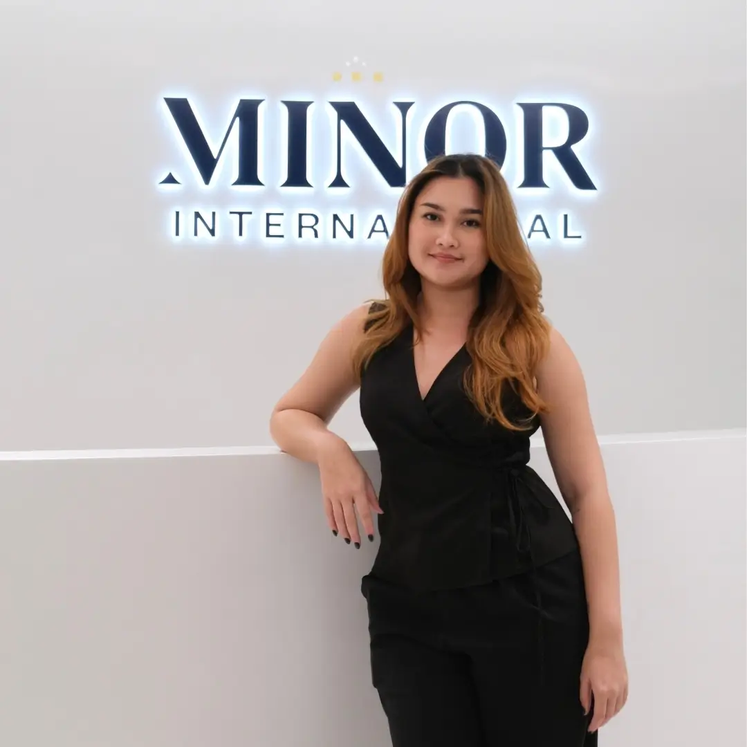 AIHM alumna standing at Minor International headquarters showcasing hospitality business and career opportunities in Bangkok