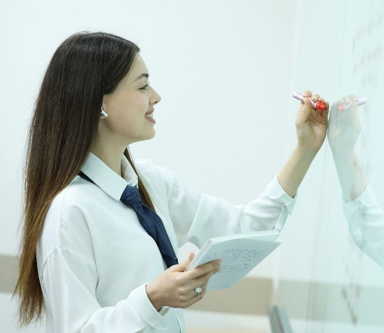 AIHM English for Business and Academic Study student practising writing and presentation skills during an interactive classroom activity.