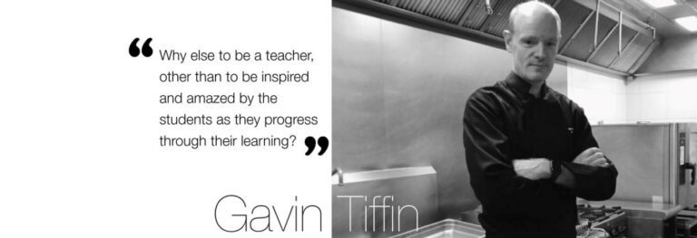 Chef Gavin Tiffin standing in a professional training kitchen beside an inspirational quote about teaching, student learning, and hospitality education at AIHM