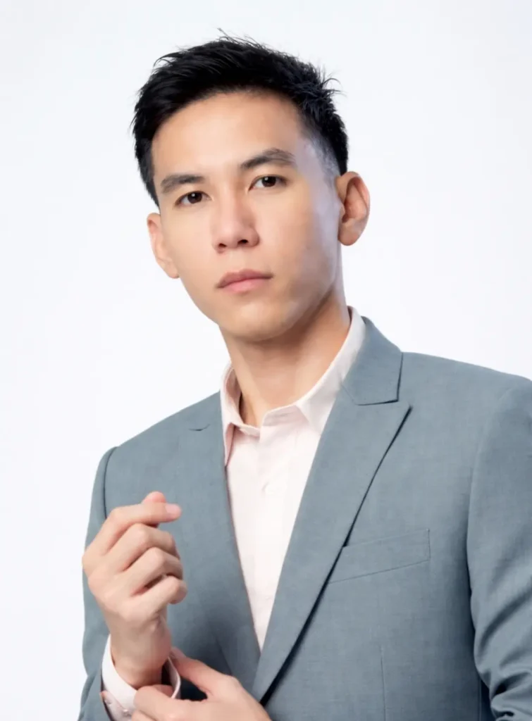 Professional portrait of AIHM English lecturer in a grey suit against a light background, highlighting academic leadership and international higher education expertise.