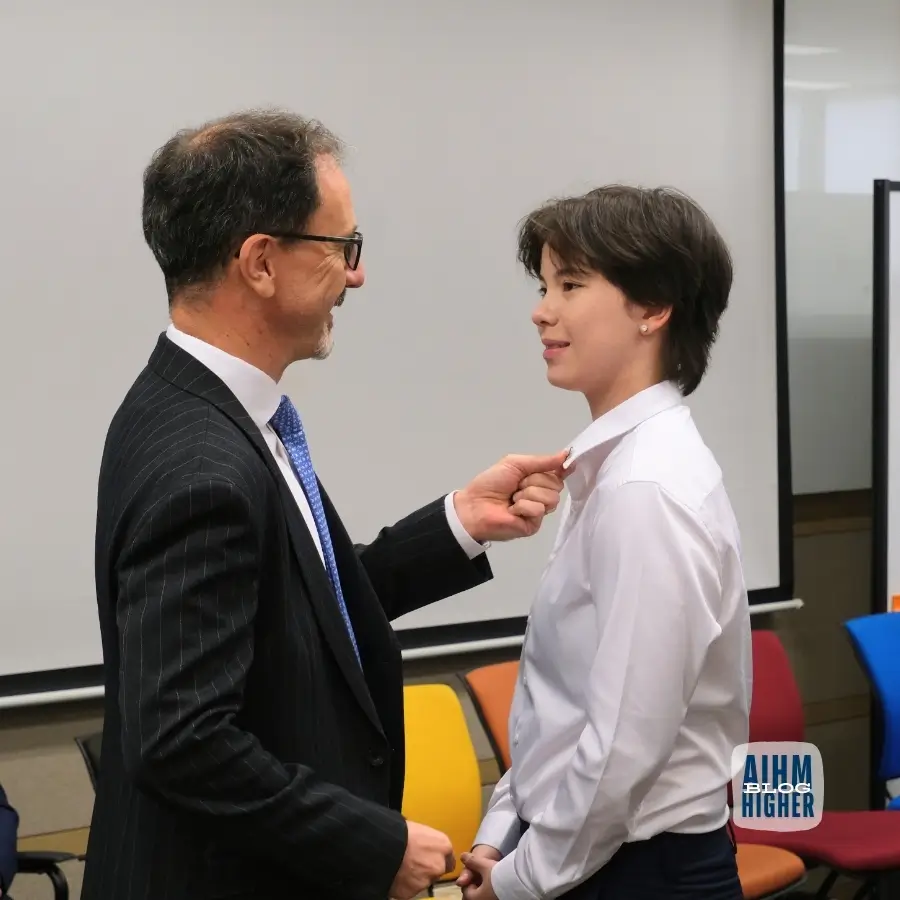 Lecturer guiding hospitality student on professional grooming standards at AIHM