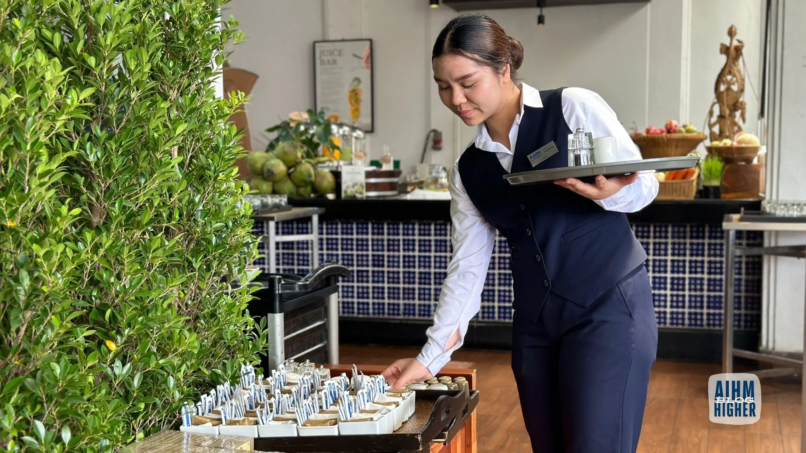 Hospitality student practicing food and beverage service during restaurant operations training at AIHM.