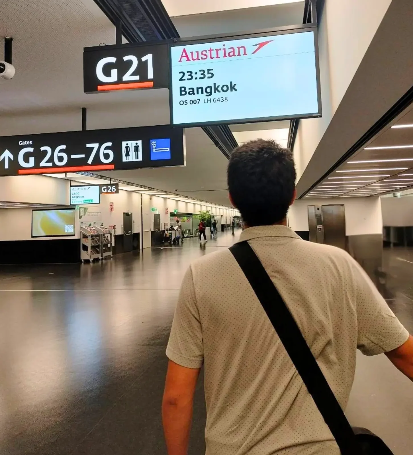 International student walking to Austrian Airlines departure gate for flight to Bangkok