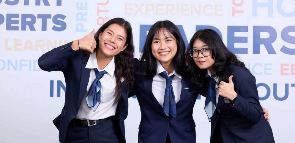 AIHM hospitality management students in formal uniform smiling and giving thumbs-up, showcasing international student life, confidence, and campus community at the Asian Institute of Hospitality Management.